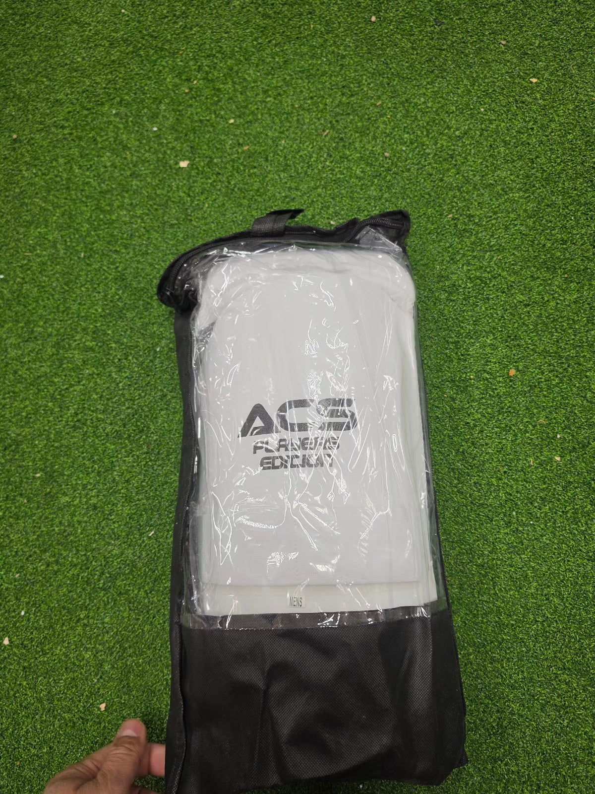 Back view of white ACS Superlite Cricket Double Thigh Pads on green turf from Albertacricketstore.com, showing the adjustable velcro straps and mesh lining.