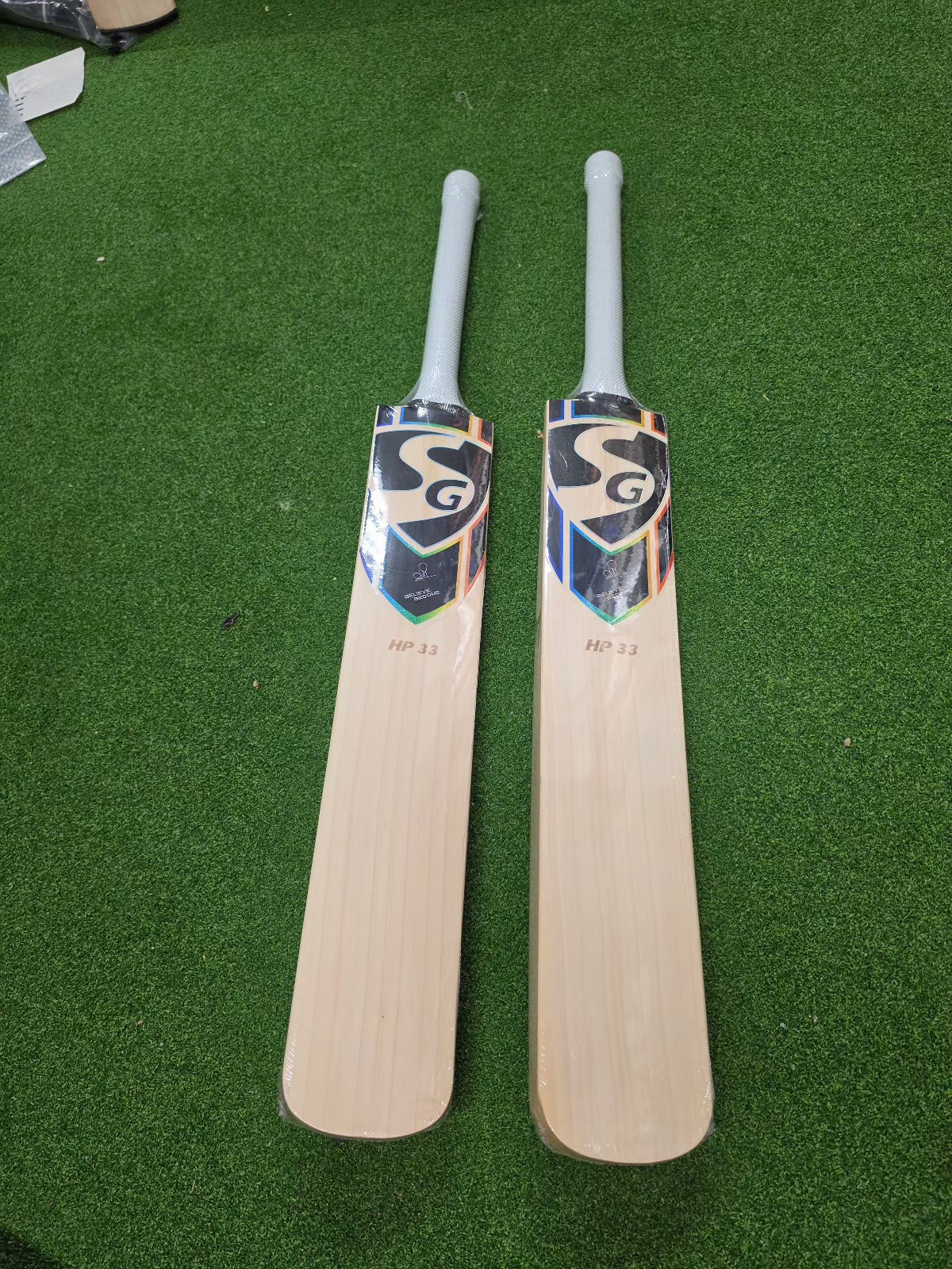 Front view of two SG HP33 2026 cricket bats showing professional branding and high-quality willow grain.