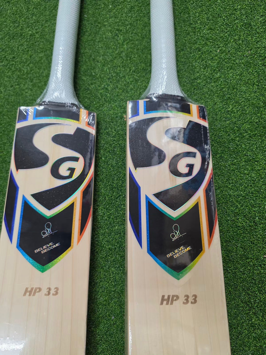 Two SG HP 33 Cricket Players Bats 2026 edition with round toe, displayed side by side on a green surface.