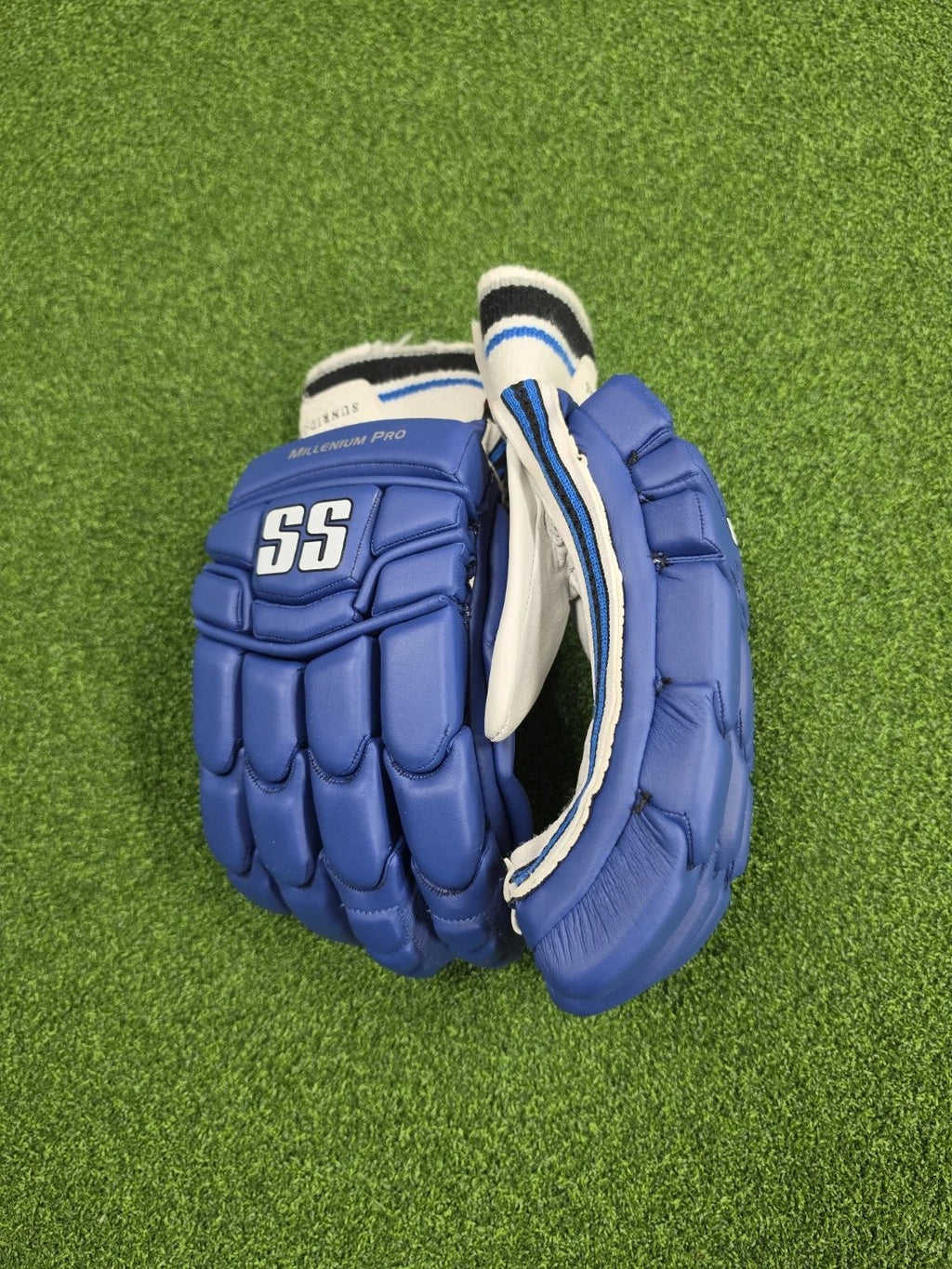 Angled backhand view of blue and white SS TON Millennium Pro adult cricket batting gloves showing SS branding and finger casing