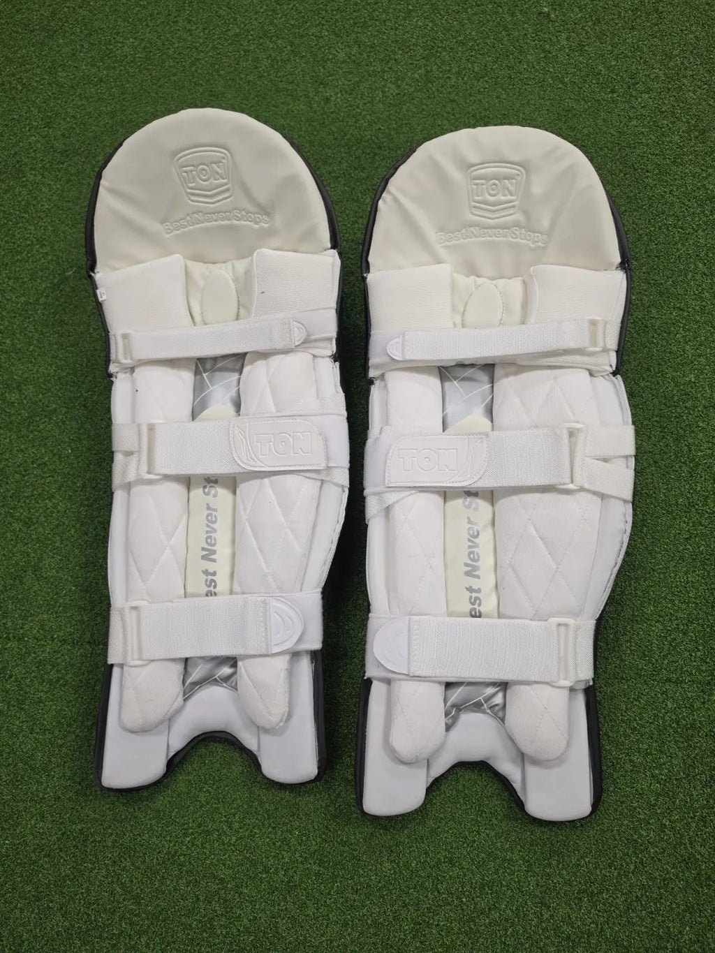 Rear view of TON Player Edition Black Batting Pads showing soft white inner bolsters and three adjustable velcro straps.