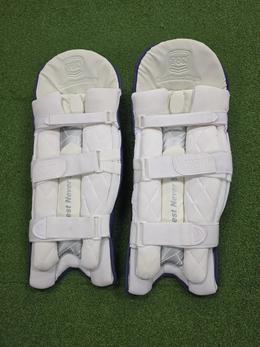 Rear view of TON Player Edition Navy Blue Batting Pads showing soft white cushioned bolsters and secure velcro straps.