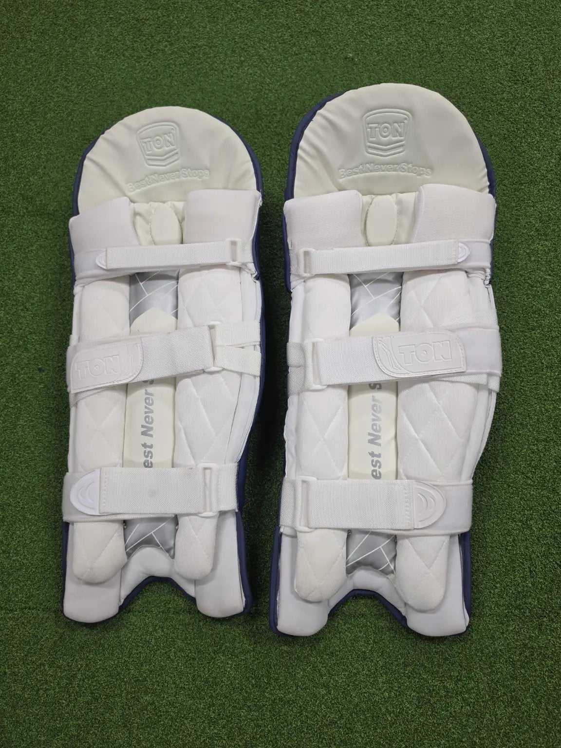 Rear view of TON Player Edition Navy Blue Batting Pads showing soft white cushioned bolsters and secure velcro straps.