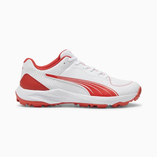 Side profile view of a white Puma 24 FH Rubber Cricket Shoe showing red Formstrip logo, cushioned white midsole, and red rubber studded outsole.