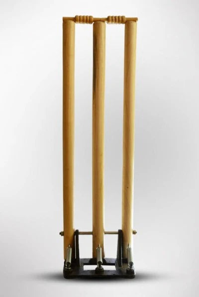 Full vertical view of the CA Spring Return Wooden Cricket Stumps mounted on a heavy-duty black cast iron spring-back base.