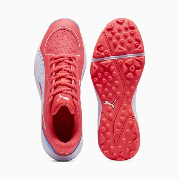 Top-down view of the pinkish-red Puma 24 FH Rubber Cricket Shoe alongside its red high-traction studded rubber outsole.