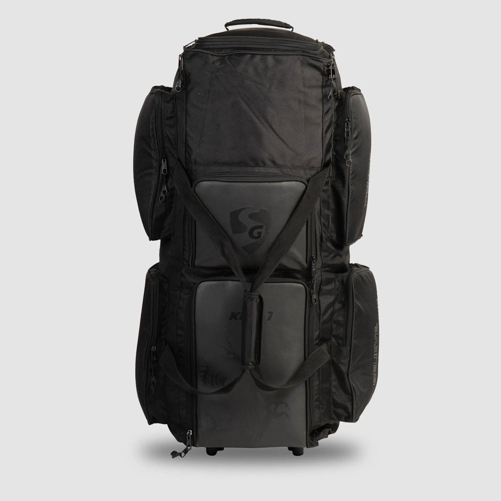 Three-quarter angle view of black SG KLR Wheelie Trunk cricket kit bag showing dual front zipped pockets and side carry straps.