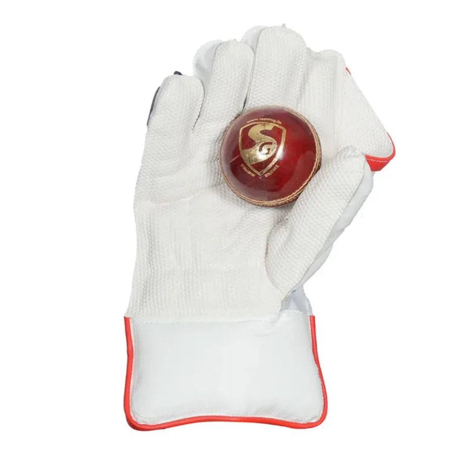 SG KLR Xtreme adult wicket keeping glove holding a red SG leather cricket ball in the palm.