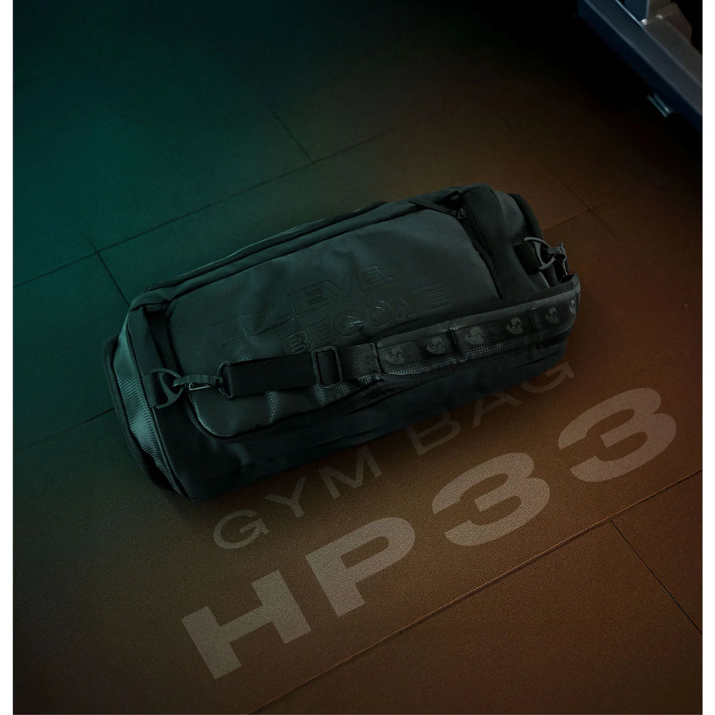 Top angle lifestyle shot of the black SG HP33 gym bag resting on a textured floor with GYM BAG HP33 text.