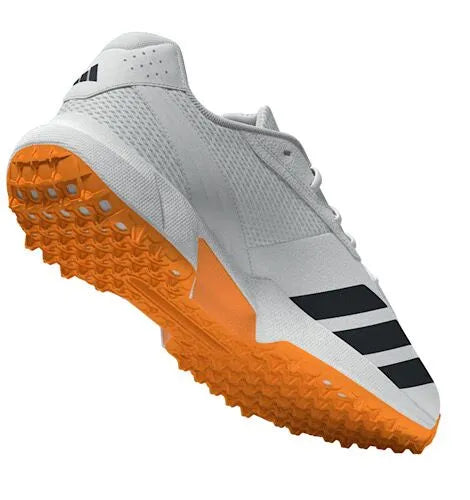Bottom-rear angled view of the white Adidas 22YDS Spikeless Cricket Shoes showcasing the durable orange rubber traction lugs and heel construction.