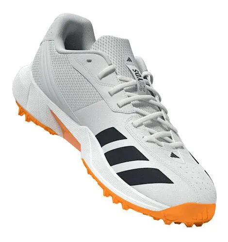 Angled front-three-quarter view of the white Adidas 22YDS Spikeless Cricket Shoes showcasing the sleek lacing system and orange outsole.