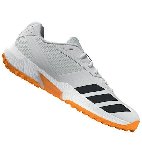 Angled side view of a white Adidas 22YDS cricket shoe with black stripes and an orange outsole.