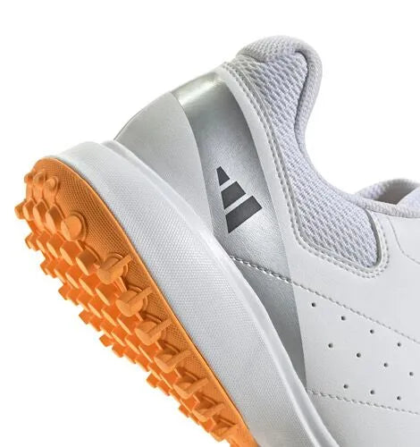 Close-up of the silver heel panel and orange outsole of a white Adidas Howzat cricket shoe.