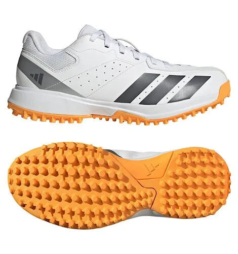 Side and bottom views of a white Adidas Howzat cricket shoe with an orange textured outsole.