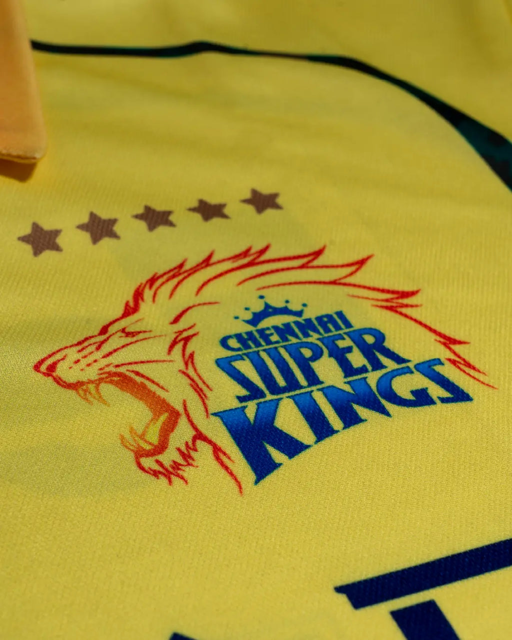 Close-up of Chennai Super Kings yellow cheer jersey with team lion logo and five stars