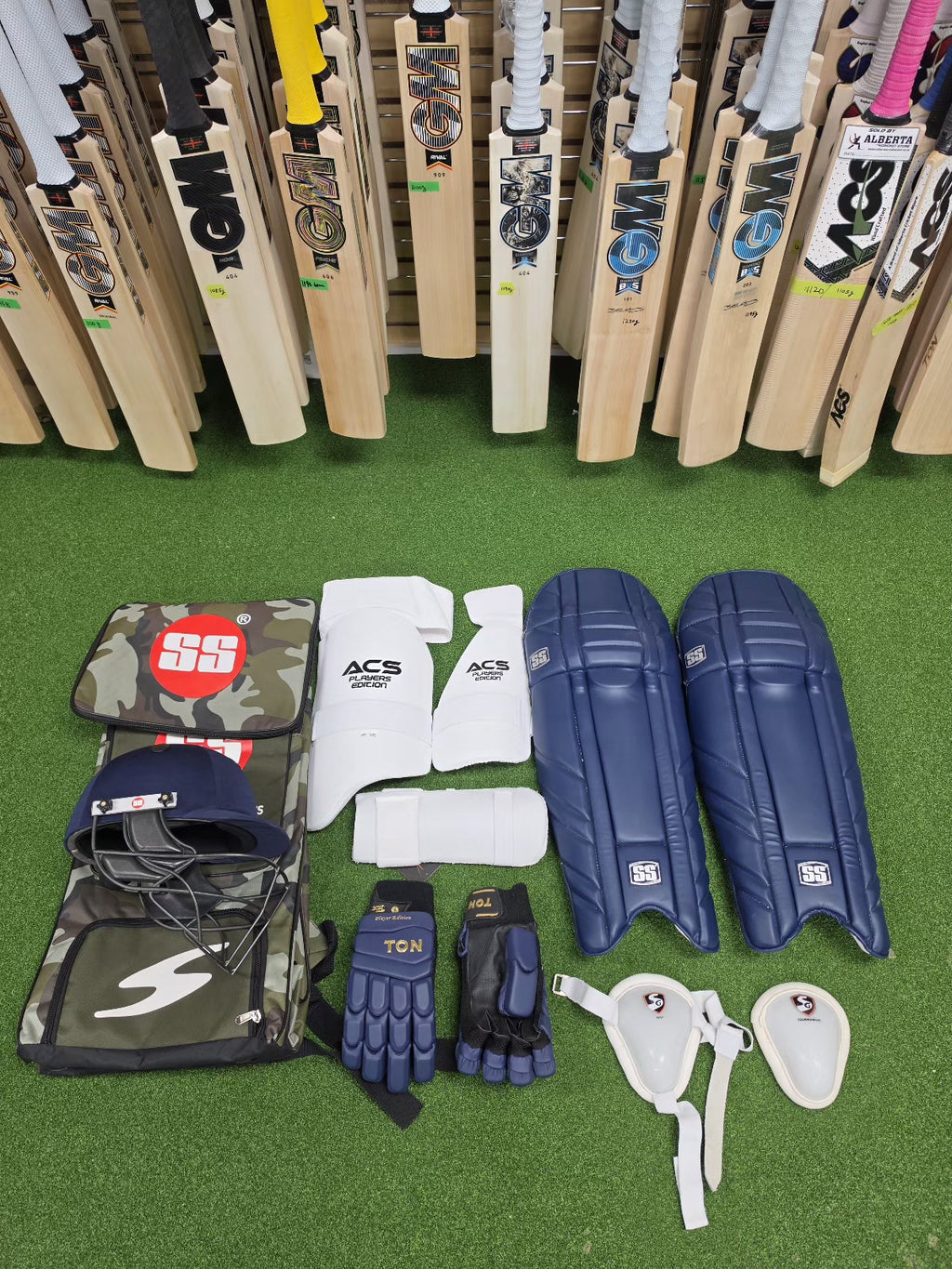 SS full cricket kit with navy blue batting pads and GM cricket bats display