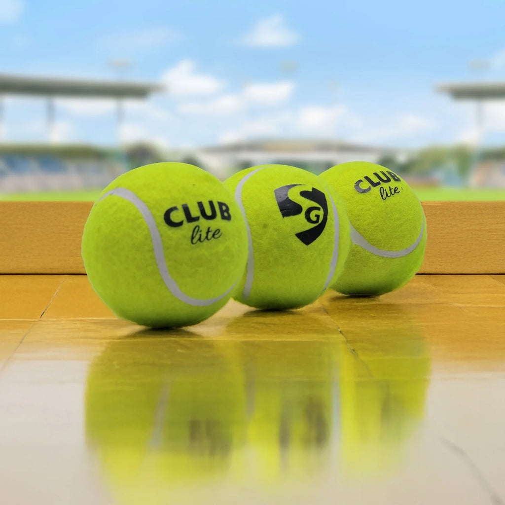 Close-up view of the black SG logo printed on a fluorescent yellow SG Club Lite cricket tennis ball against a white background.